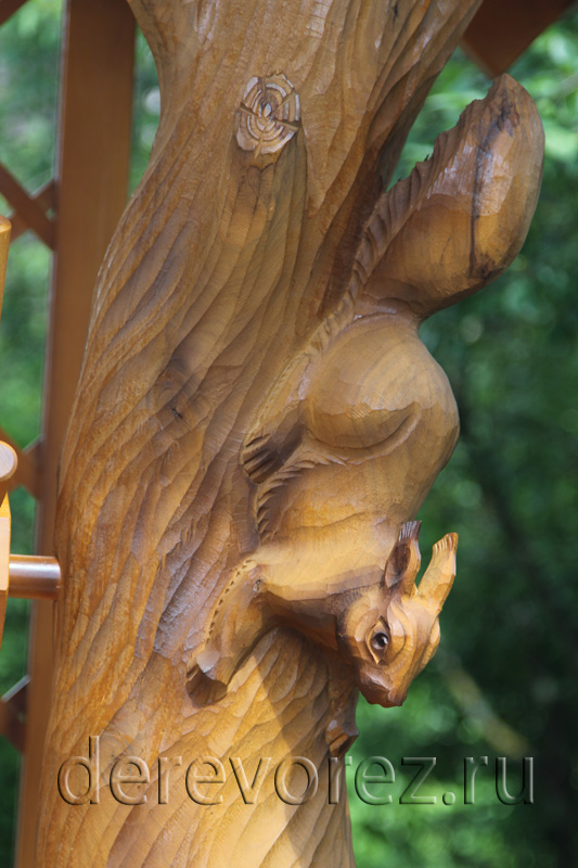 Белка, динамично несущаяся вниз по стволу дерева, украшает домик для колодца